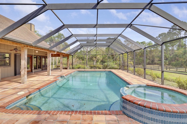 view of swimming pool with an in ground hot tub, a lanai, ceiling fan, and a patio area