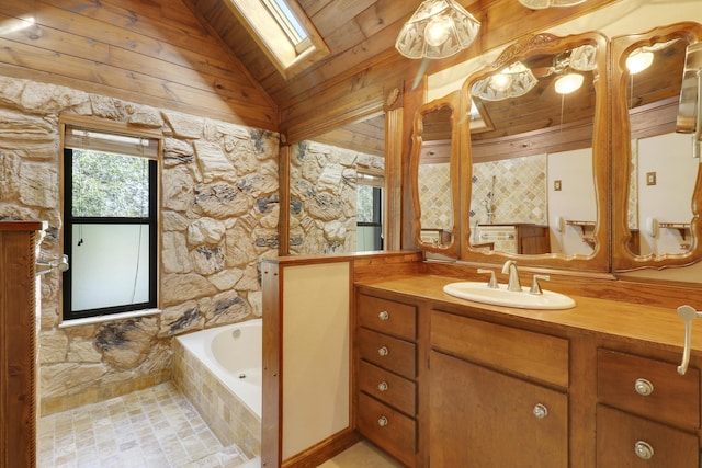 bathroom featuring a relaxing tiled tub, vanity, lofted ceiling with skylight, and wooden ceiling