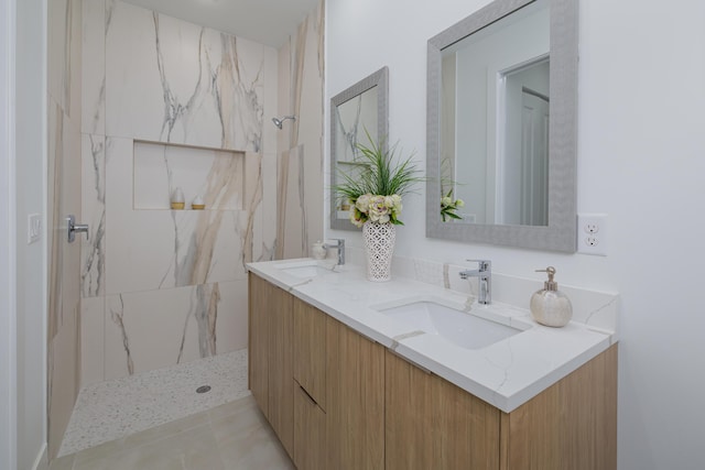 bathroom featuring tiled shower, vanity, and tile patterned flooring