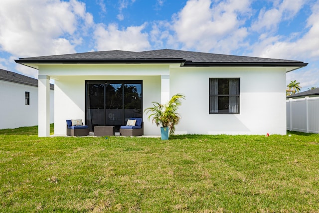 rear view of house featuring outdoor lounge area and a yard