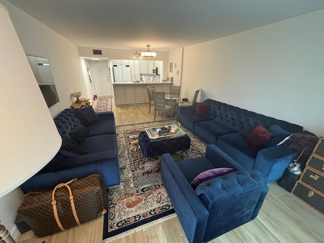 living room featuring a notable chandelier and light hardwood / wood-style flooring