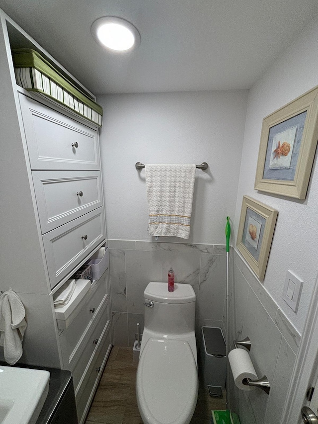 bathroom featuring hardwood / wood-style flooring, vanity, tile walls, and toilet