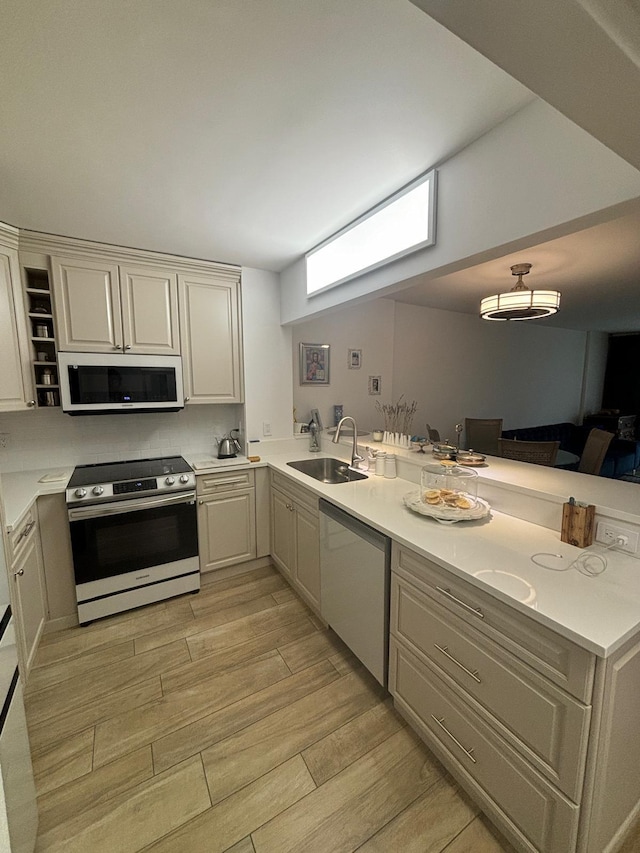 kitchen featuring sink, kitchen peninsula, and appliances with stainless steel finishes