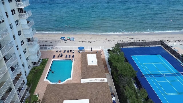 drone / aerial view with a water view and a beach view