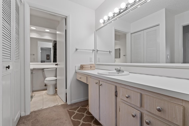 bathroom featuring vanity, tile patterned floors, a textured ceiling, and toilet