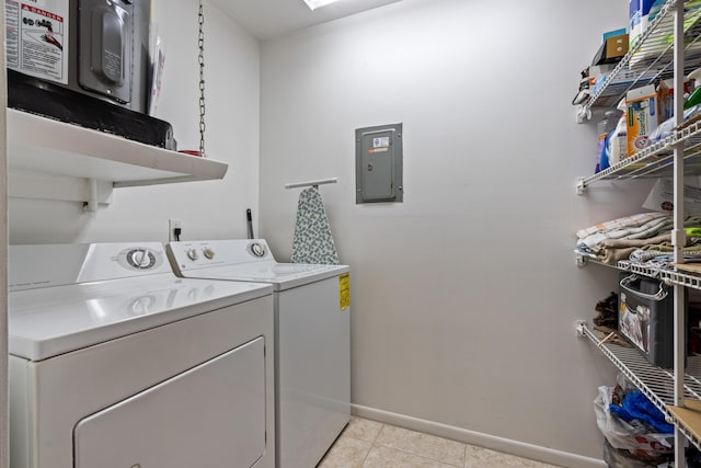 laundry area featuring light tile patterned floors, electric panel, and washing machine and clothes dryer