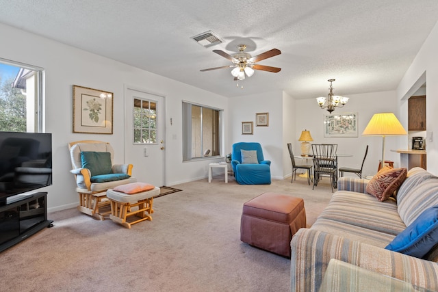 living room with light carpet, ceiling fan with notable chandelier, and a textured ceiling