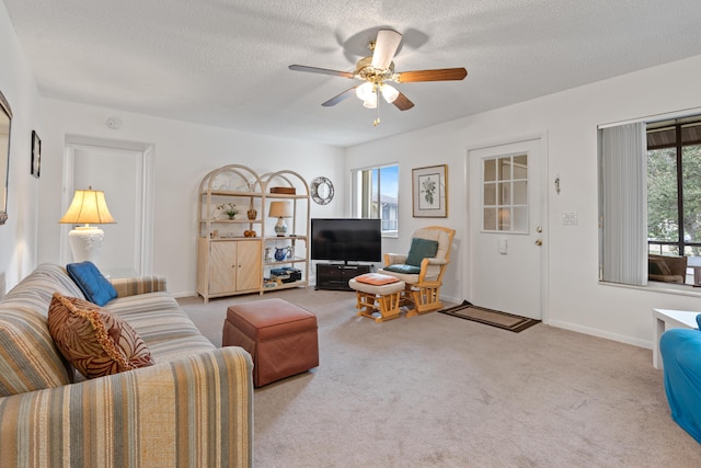 carpeted living room with ceiling fan and a textured ceiling