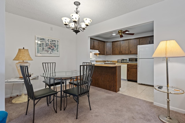 dining room featuring ceiling fan with notable chandelier, light colored carpet, and a textured ceiling