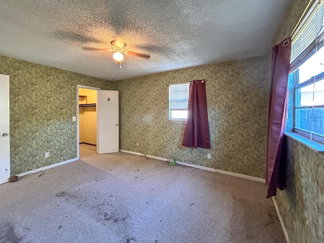 unfurnished bedroom with ceiling fan, carpet floors, and a textured ceiling