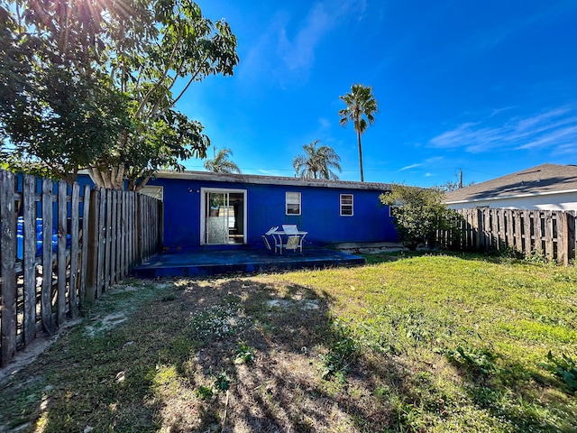 rear view of property featuring a patio and a lawn