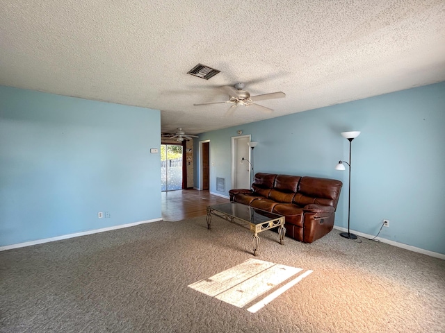 living room with ceiling fan, carpet, and a textured ceiling