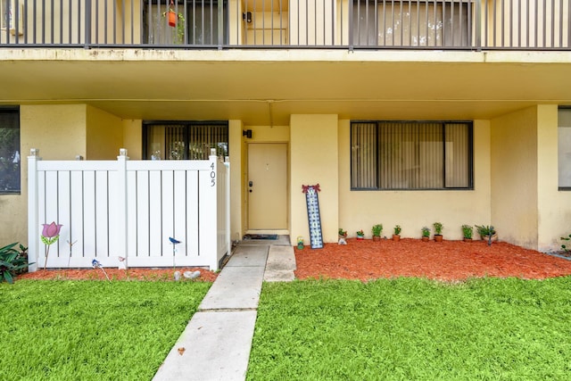 view of exterior entry with a lawn