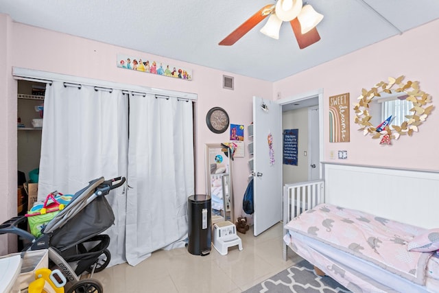 tiled bedroom featuring ceiling fan