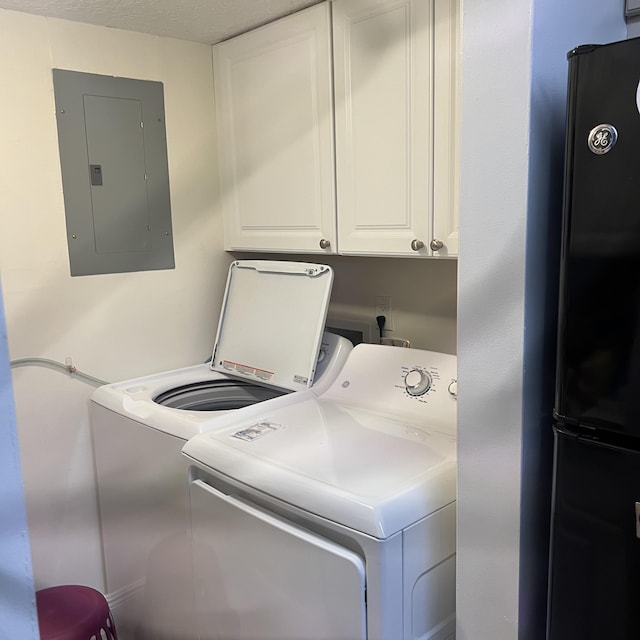 washroom featuring washer and clothes dryer, electric panel, cabinets, and a textured ceiling