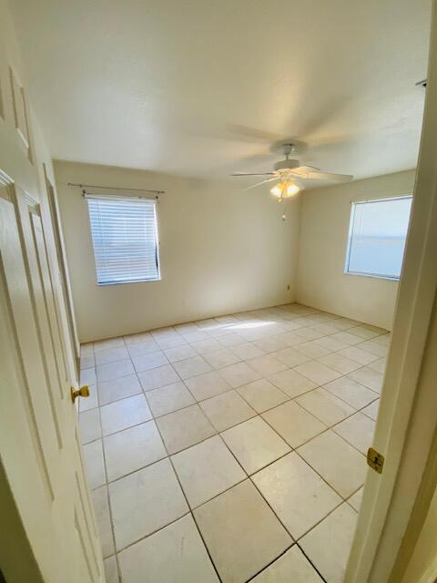 tiled empty room with ceiling fan