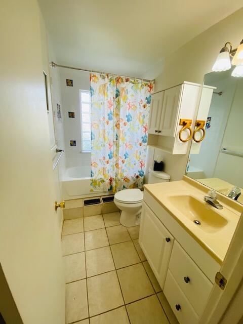 full bathroom featuring tile patterned flooring, vanity, toilet, and shower / bath combo