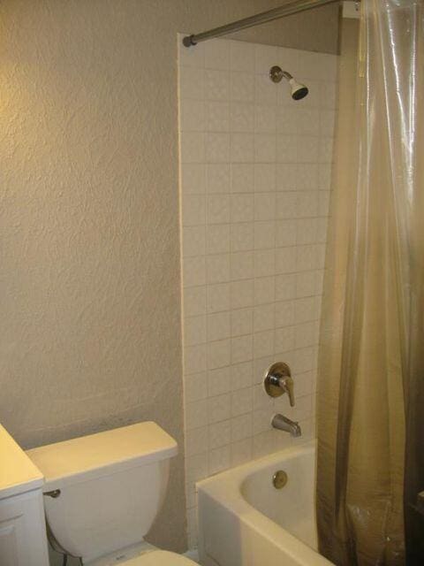 full bathroom featuring shower / tub combo with curtain, vanity, and toilet