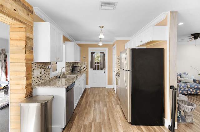 kitchen featuring light wood-type flooring, stainless steel appliances, sink, and white cabinets