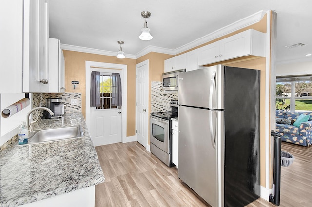 kitchen featuring appliances with stainless steel finishes, sink, white cabinets, hanging light fixtures, and crown molding