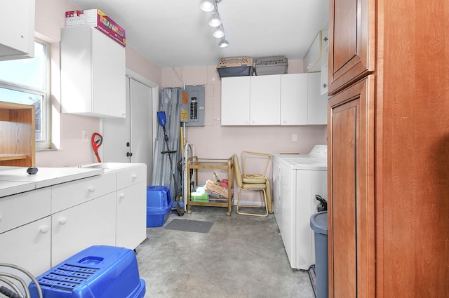 washroom with cabinets, washing machine and clothes dryer, and electric panel