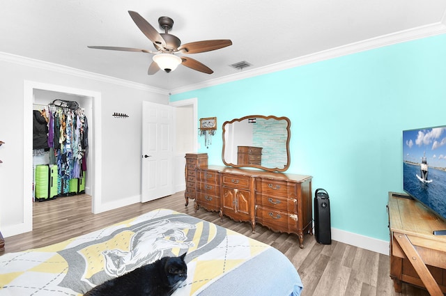 bedroom featuring ceiling fan, ornamental molding, and hardwood / wood-style floors