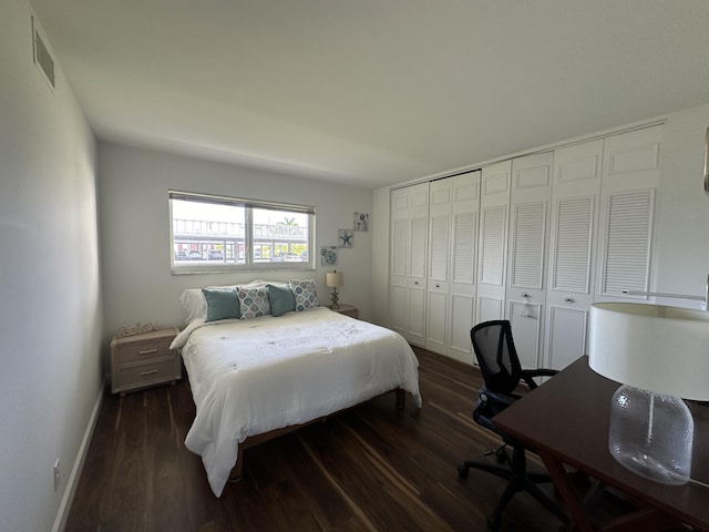 bedroom with dark wood-type flooring and a closet