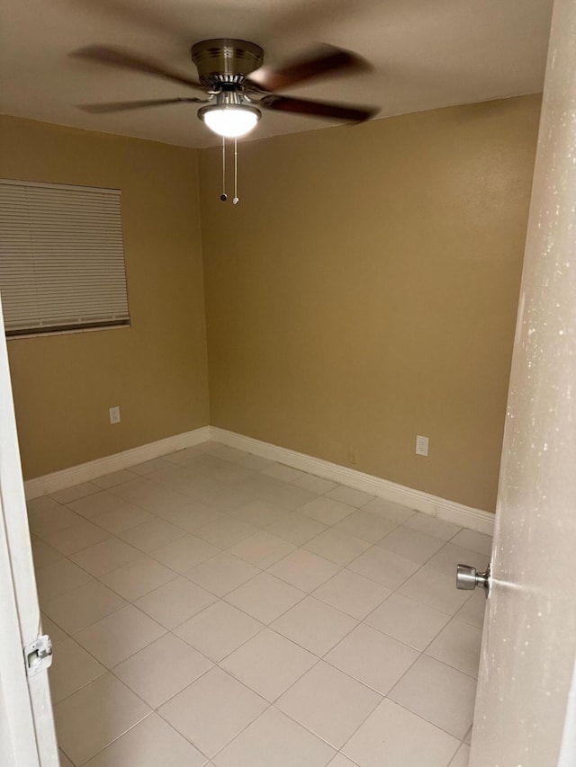 spare room with ceiling fan and light tile patterned floors