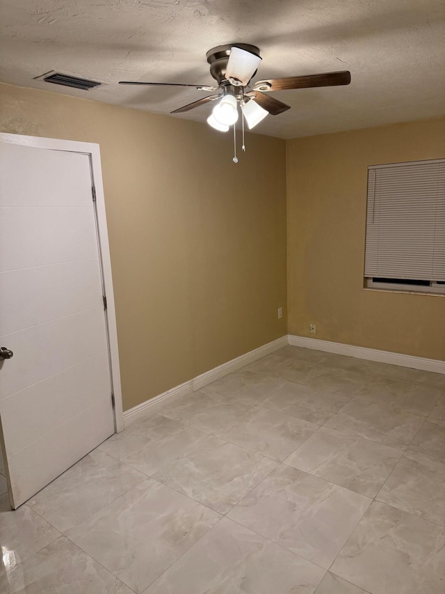 spare room featuring ceiling fan and a textured ceiling