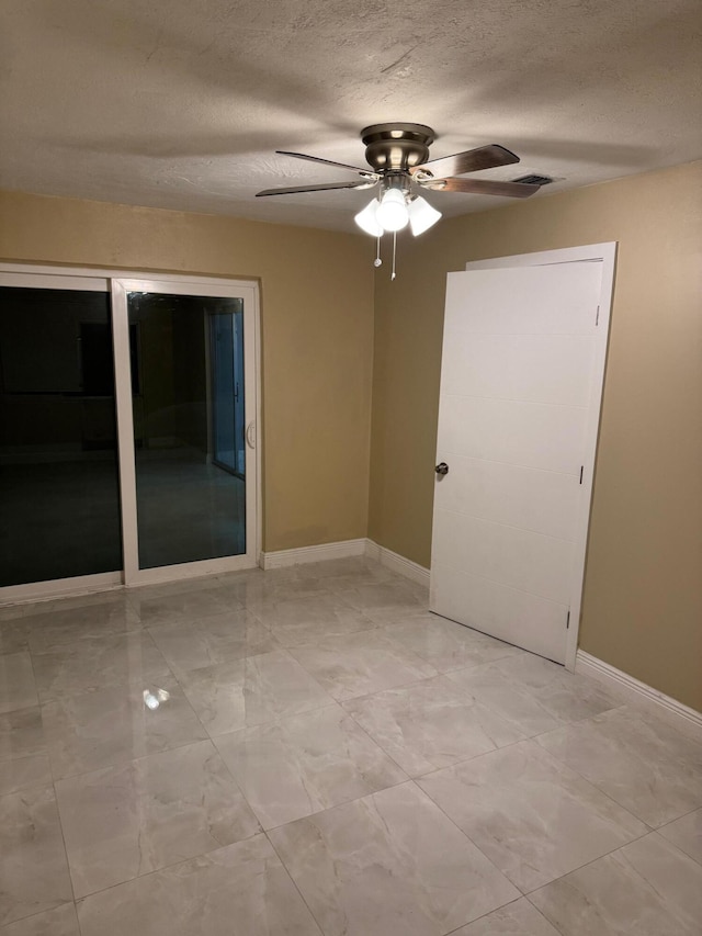 spare room with ceiling fan and a textured ceiling