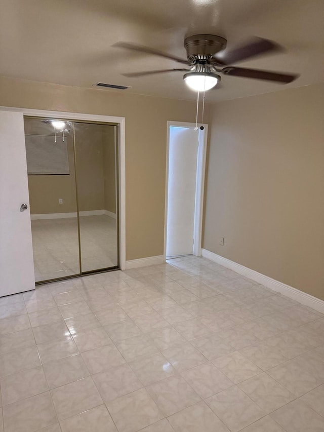 unfurnished bedroom with ceiling fan and a closet