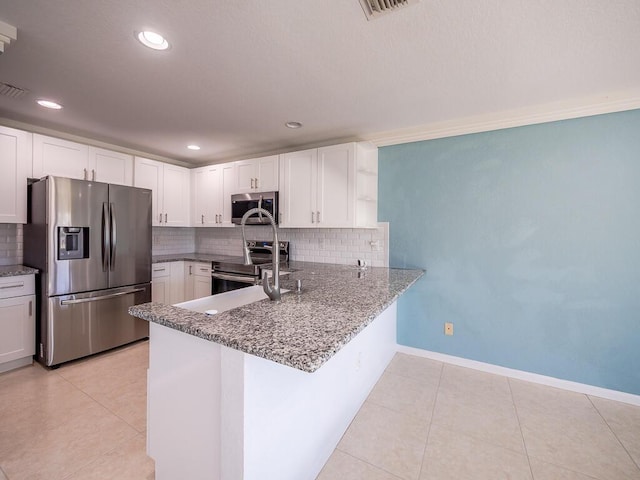 kitchen featuring white cabinetry, light tile patterned floors, kitchen peninsula, and appliances with stainless steel finishes