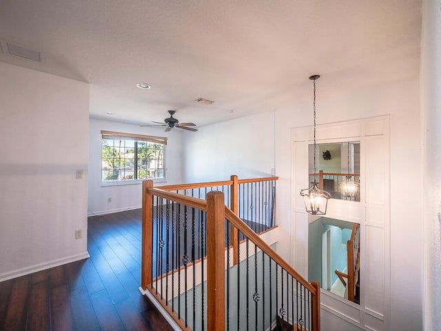 hall with dark hardwood / wood-style floors and a chandelier