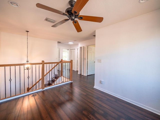 unfurnished room with dark wood-type flooring and a notable chandelier