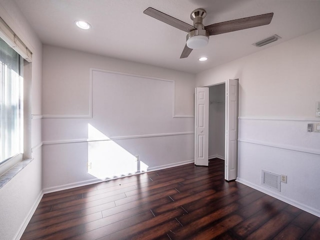 unfurnished bedroom featuring dark wood-type flooring, ceiling fan, and a closet