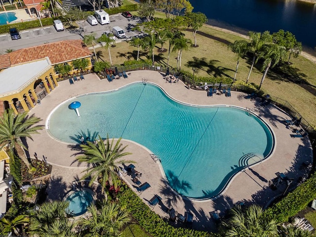 view of swimming pool featuring a patio and a water view