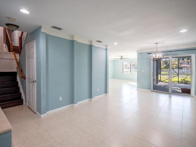 spare room featuring crown molding, ceiling fan with notable chandelier, and light tile patterned floors