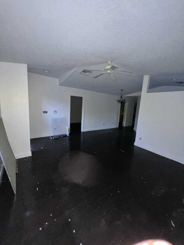 unfurnished living room featuring ceiling fan and a textured ceiling