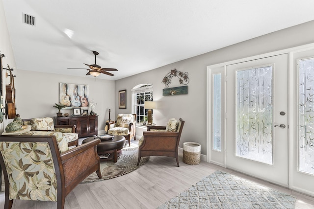 living room with ceiling fan and light hardwood / wood-style flooring