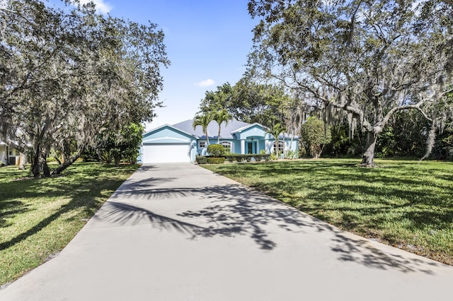 view of front of property with a garage and a front lawn