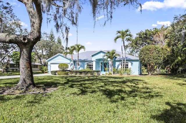 single story home featuring a garage and a front lawn