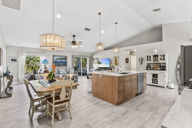 kitchen with pendant lighting, sink, appliances with stainless steel finishes, a kitchen island with sink, and a healthy amount of sunlight