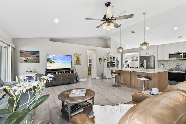 living room featuring vaulted ceiling, ceiling fan, and light hardwood / wood-style floors