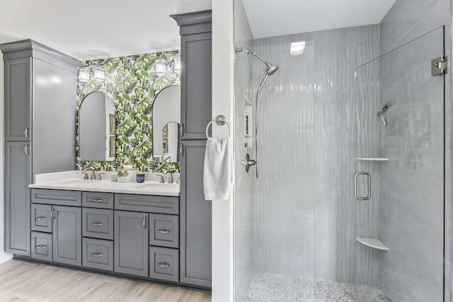 bathroom featuring vanity, hardwood / wood-style flooring, and a shower with door