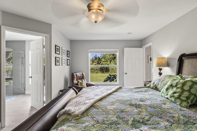 bedroom featuring ceiling fan, a textured ceiling, and light wood-type flooring