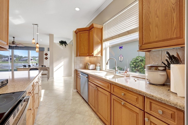 kitchen featuring appliances with stainless steel finishes, decorative light fixtures, tasteful backsplash, sink, and light stone counters