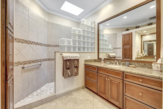 bathroom with vanity, ornamental molding, tiled shower, and a skylight