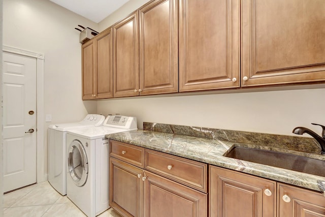 washroom with cabinets, washing machine and dryer, sink, and light tile patterned floors