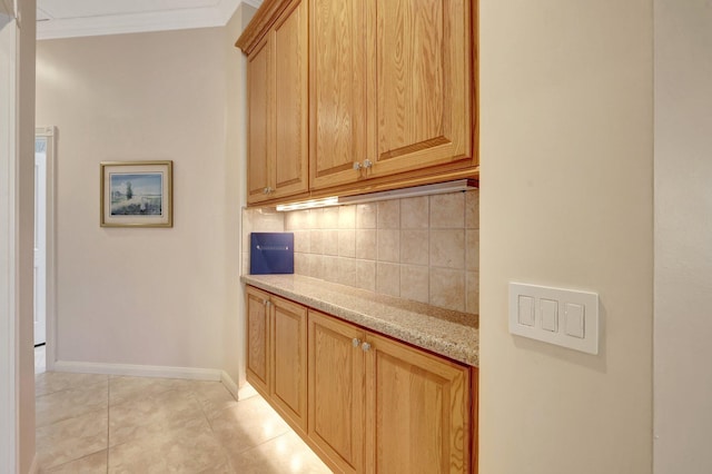 interior space featuring ornamental molding, light tile patterned floors, light stone counters, and decorative backsplash