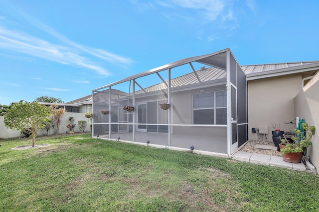 back of property featuring a lanai and a yard